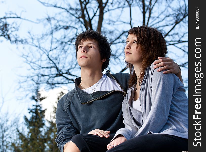 Young couple in the park, blue sky in background