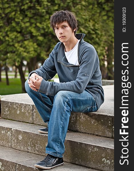 Young man sitting on stairs, outdoor