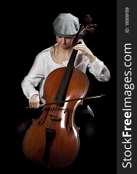 Girl playing cello, in black background