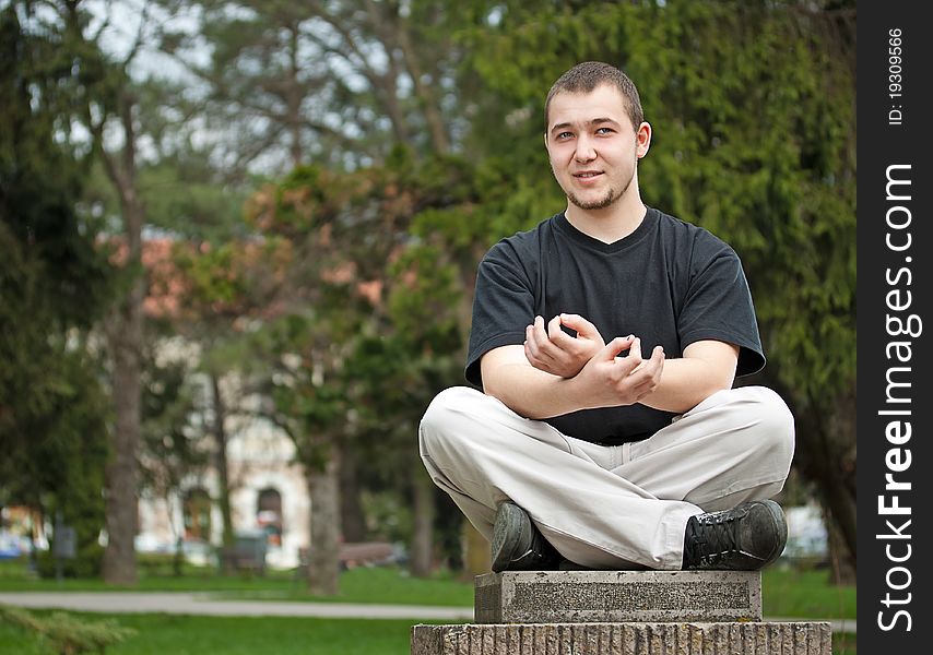 Young man doing yoga at the park