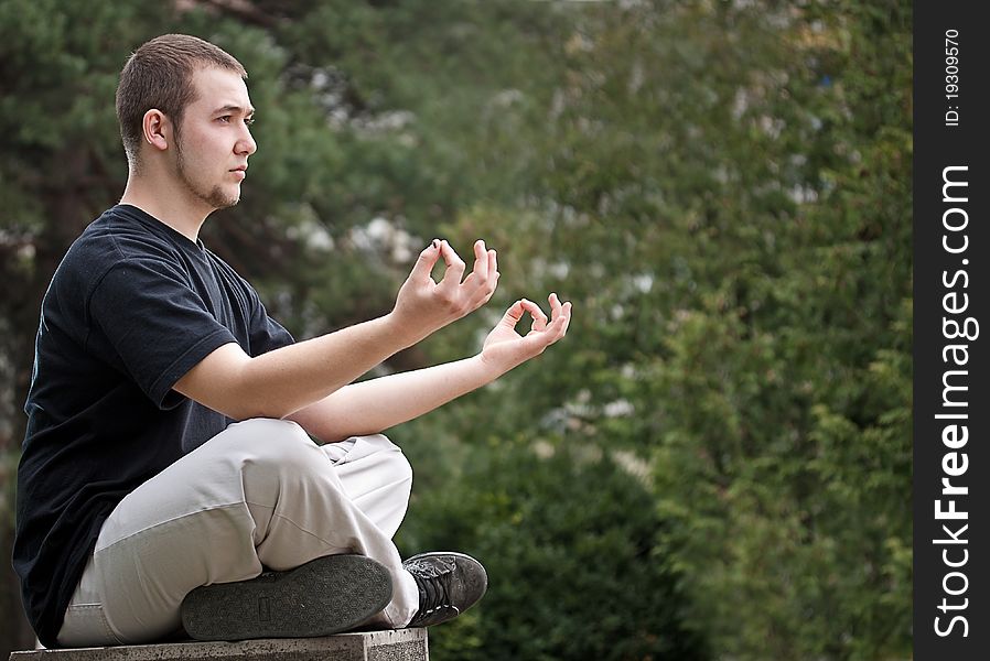 Young man doing yoga at the park