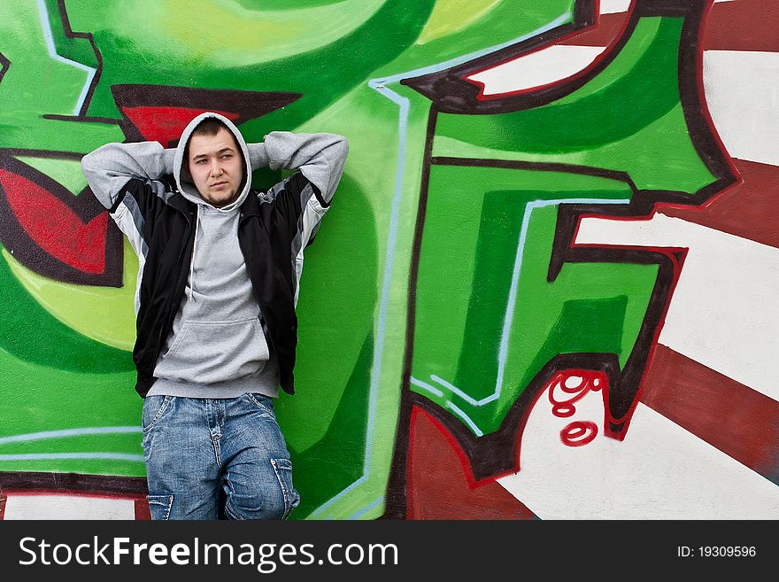 Man leaning against wall with graffiti