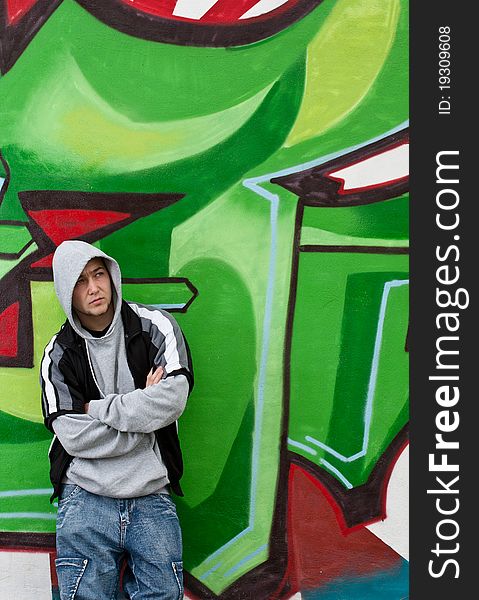 Man leaning against wall with graffiti