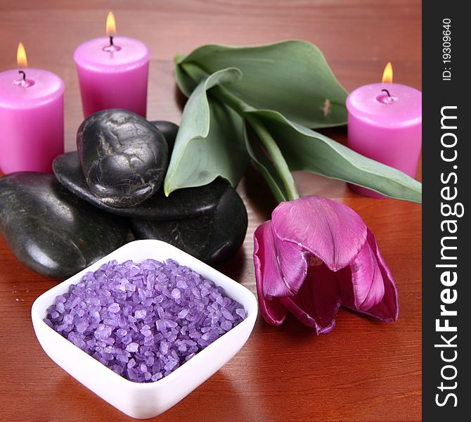 Lavender spa salt, spa stones, candles and a tulip flower. Lavender spa salt, spa stones, candles and a tulip flower