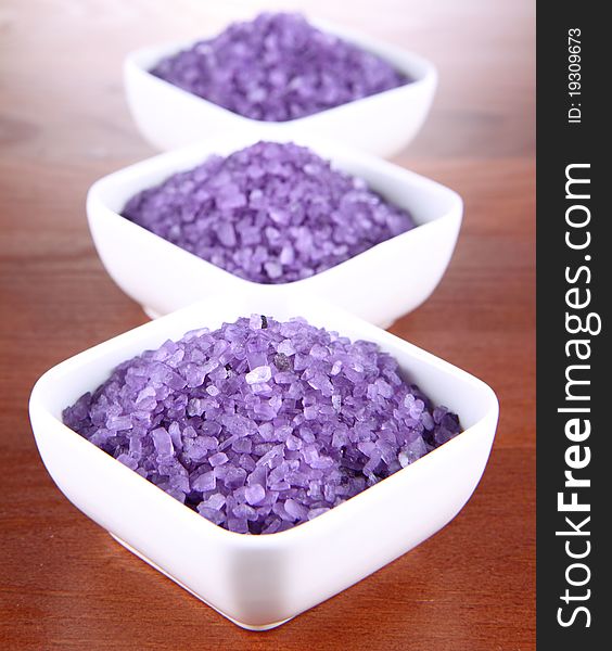 Lavender spa salt in white bowls on a wooden background