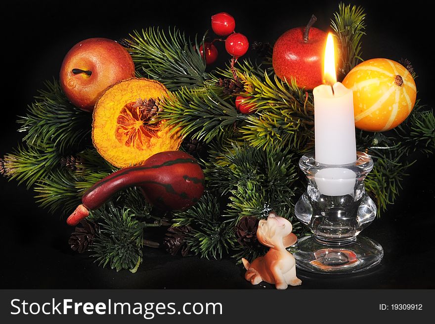 Christmas ornaments  and  burning a candle against a dark background