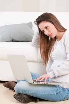 Absorbed Young Woman Working On Laptop Royalty Free Stock Photography