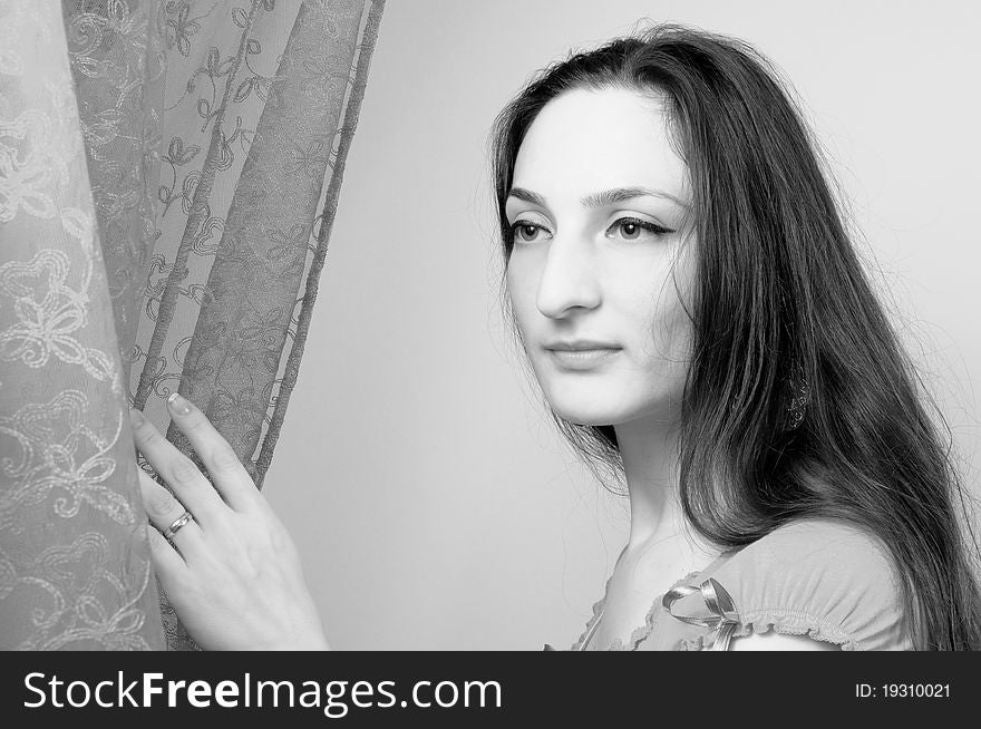 Portrait of a beautiful girl with long hair Under the Curtains