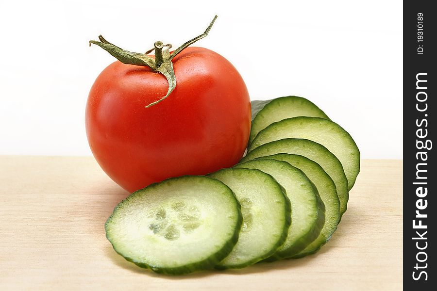 Cucumber and tomato on a wooden board