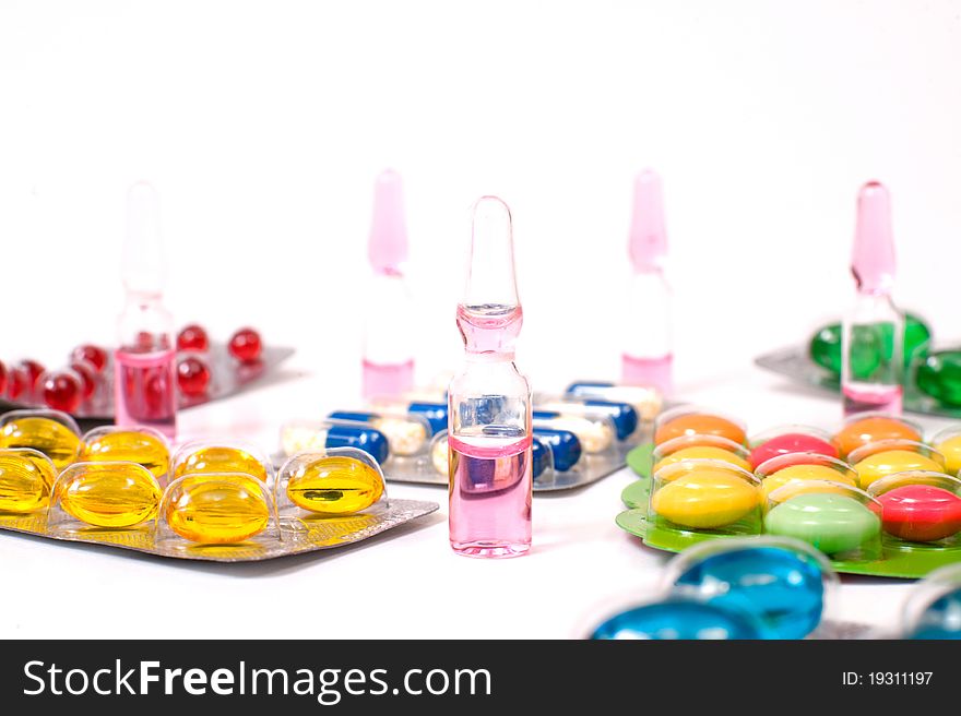 Various pills and vials on white