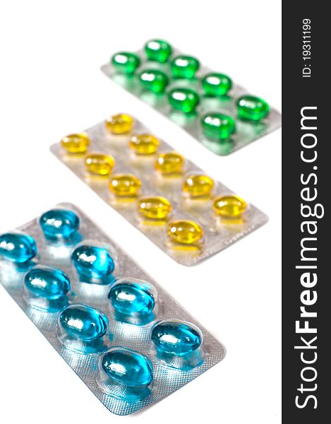 Colored pills in blisters on white background