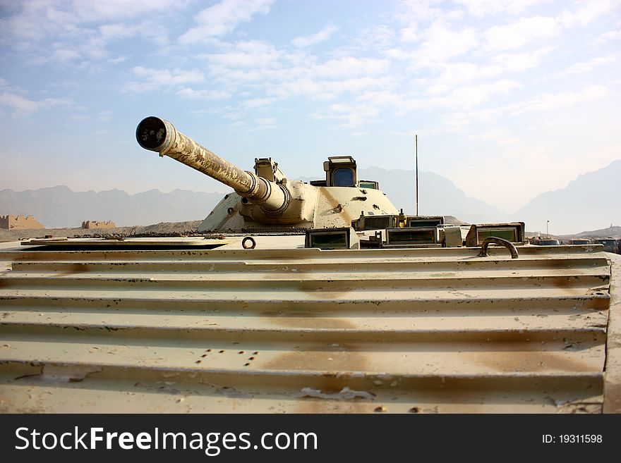 A cannon of BMP-1 over cloudy sky and mountain background