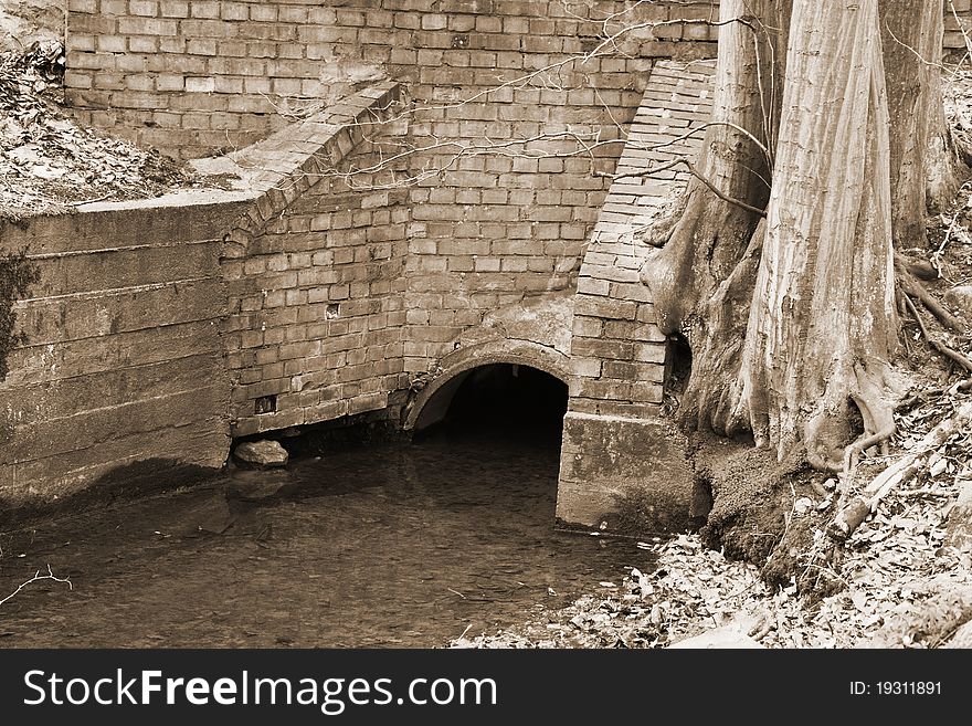 Old bridge over a stream in sepia