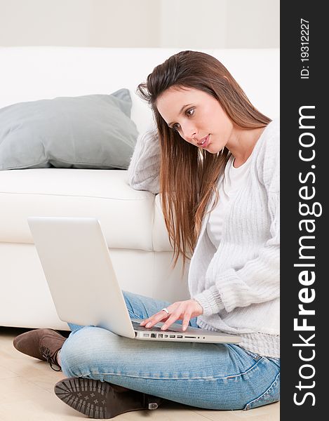 Young absorbed lady watching at her laptop at home. Young absorbed lady watching at her laptop at home