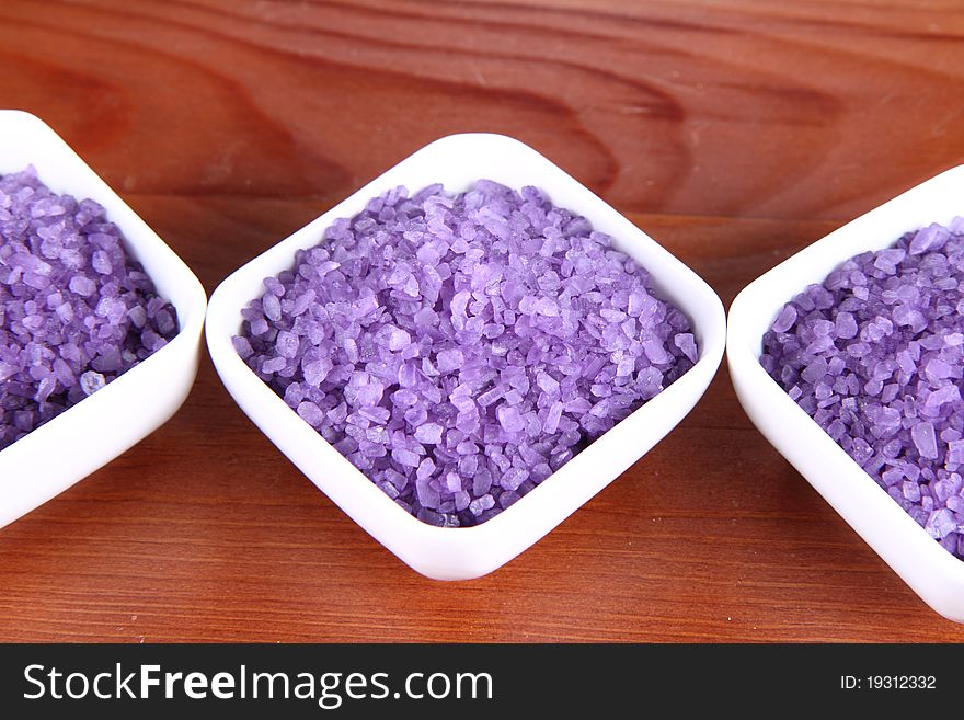 Lavender spa salt in white bowls on a wooden background
