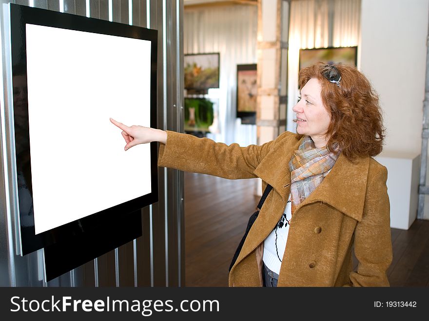 The redhead woman points to a picture