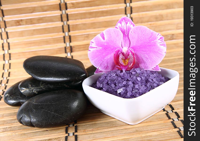 Lavender spa salt, spa stones and an orchid flower. Lavender spa salt, spa stones and an orchid flower