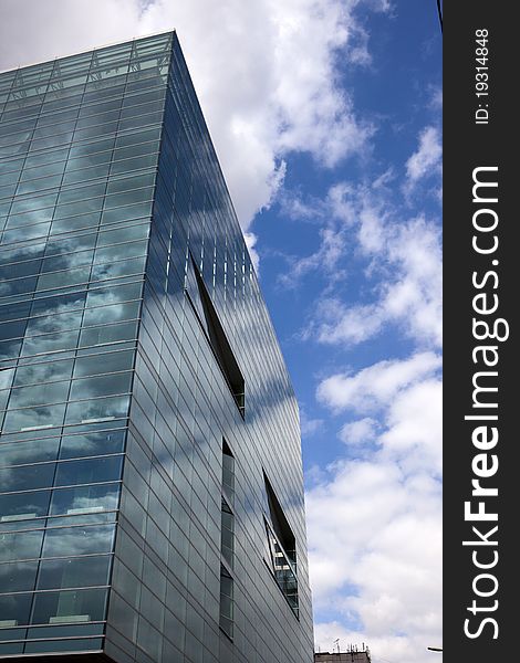 Modern multi-storey building with glass windows in which are reflected the clouds. Modern multi-storey building with glass windows in which are reflected the clouds