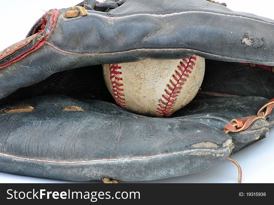 Closeup of an old baseball glove with a baseball in the pocket