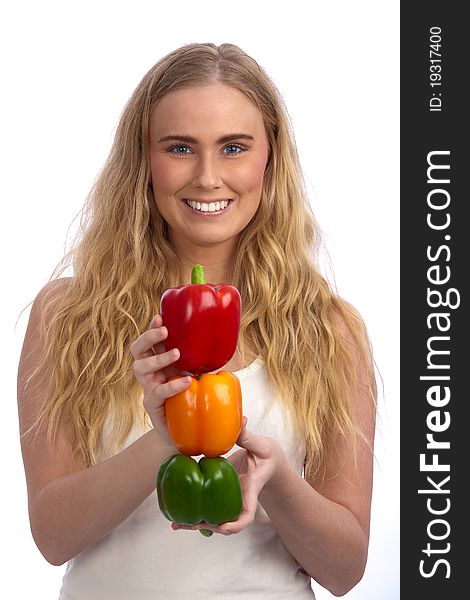 Beautiful blond caucasian young woman smiling and holding a traffic light of three bell peppers: red, orange, and green. Beautiful blond caucasian young woman smiling and holding a traffic light of three bell peppers: red, orange, and green