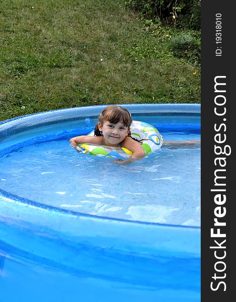 Little cute girl having fun swimming in a pool. Summer time, hot day. Little cute girl having fun swimming in a pool. Summer time, hot day.