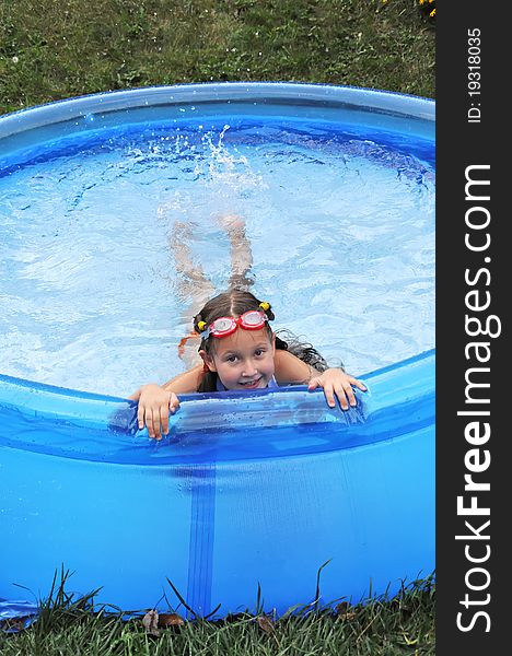 Little cute girl having fun swimming in a pool. Summer time, hot day. Little cute girl having fun swimming in a pool. Summer time, hot day.