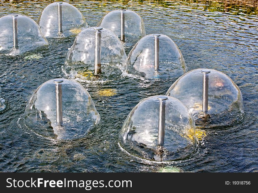 A group of small sperical fountains on a water in a sunny day. A group of small sperical fountains on a water in a sunny day