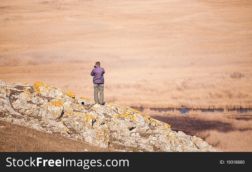 Photographer taking photos of canals of a like covered with reed, in spring.