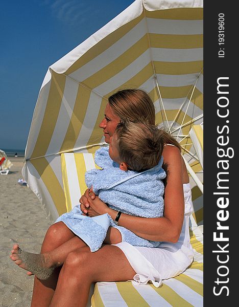 Young woman with her son sitting on beach chair. Young woman with her son sitting on beach chair