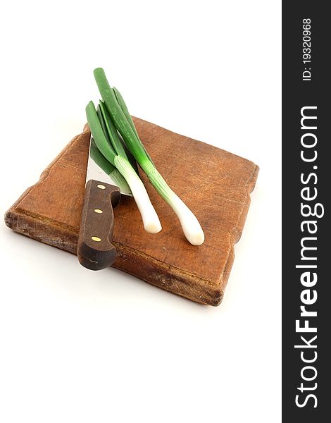 Stone leek with knife on wooden cutting board