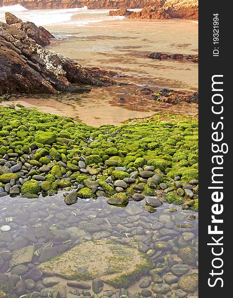 Beach of green stones in Cavaleiro at Alentejo, Portugal