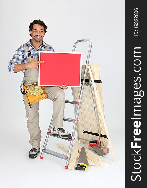 Smiling laborer with ladder and red panel