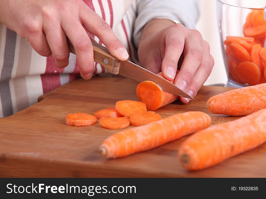 Character cutting carrots on wooden board. Character cutting carrots on wooden board
