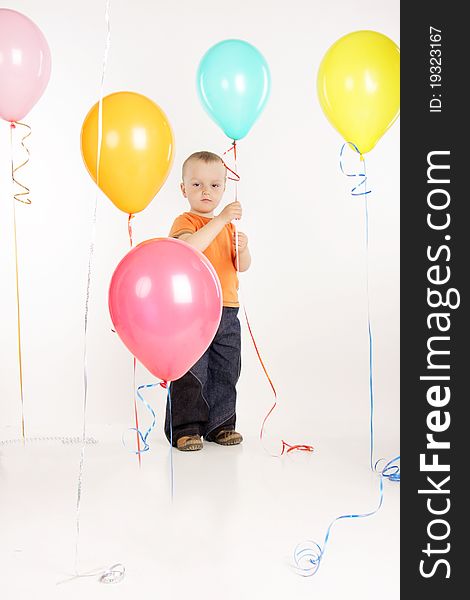 Young boy with colorful balloons over white. Young boy with colorful balloons over white