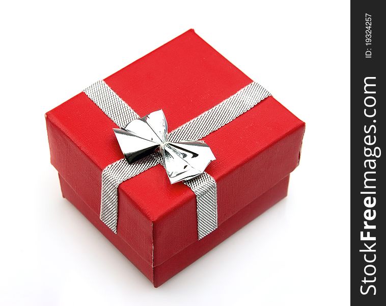 Single red gift box with silver ribbon on white background.