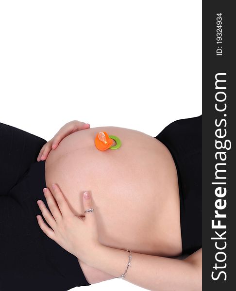 Colourful pacifier resting on top of a bare pregnant belly. woman with hands on belly. isolated on white. Colourful pacifier resting on top of a bare pregnant belly. woman with hands on belly. isolated on white.