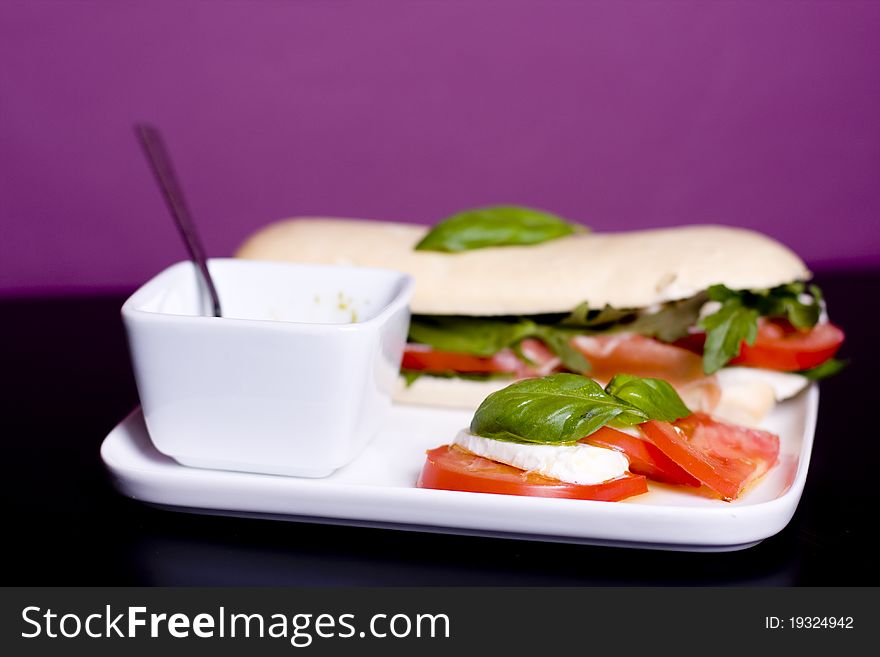 Long baguette sandwich with ham,  fresh vegetables and pesto. Long baguette sandwich with ham,  fresh vegetables and pesto