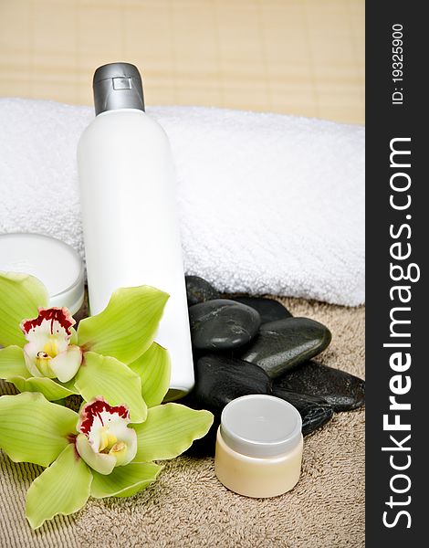 Different spa products: cosmetics, massage stones, towels, orchids. Different spa products: cosmetics, massage stones, towels, orchids