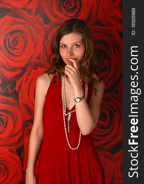 Girl in red dress posing at wall with red wallpaper. Girl in red dress posing at wall with red wallpaper.
