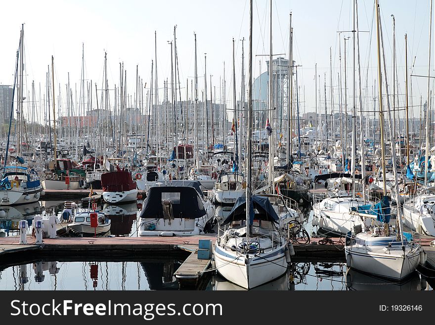 Yachts and speed boats reflecting in the water in the marina. Barcelona - Spain. Yachts and speed boats reflecting in the water in the marina. Barcelona - Spain