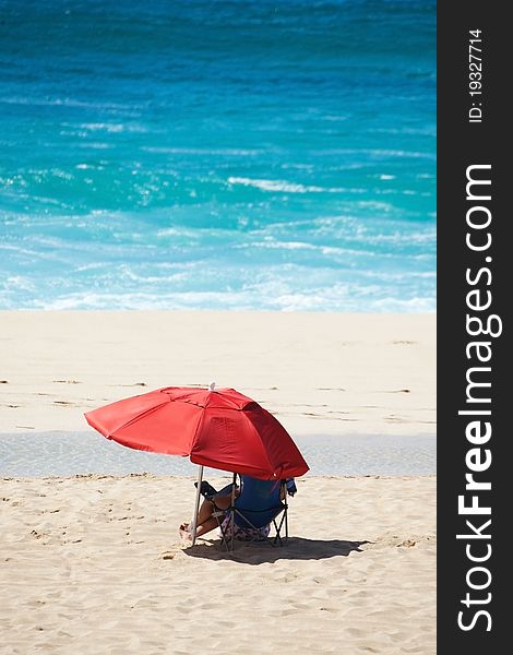 Beach Scene With Red Umbrella And Blue Water