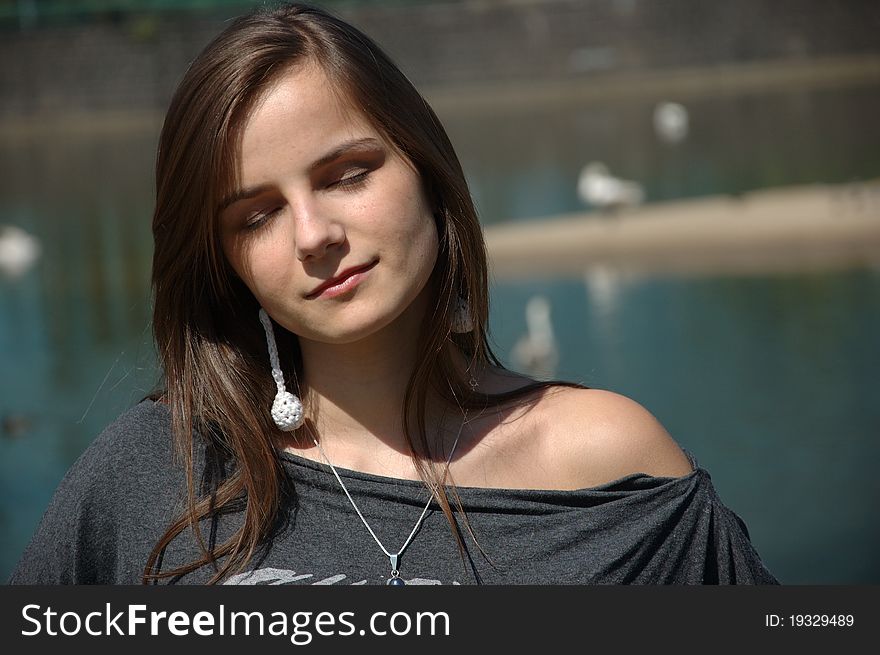 Closed eyes portrait of young girl. Teenage model dreaming with her eyes closed, water as background. Closed eyes portrait of young girl. Teenage model dreaming with her eyes closed, water as background.