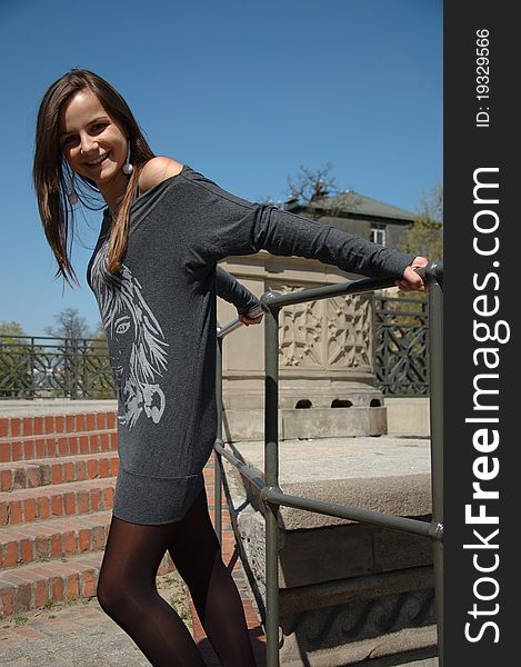 Sweet, young girl portrait on the stairs. Teenage model in Poland wearing casual dress, smiling gently. Sweet, young girl portrait on the stairs. Teenage model in Poland wearing casual dress, smiling gently.