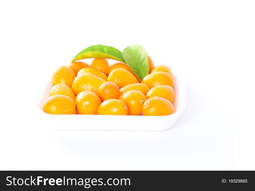 Exotic kumquat set with green leaves on white. tropical fruit background