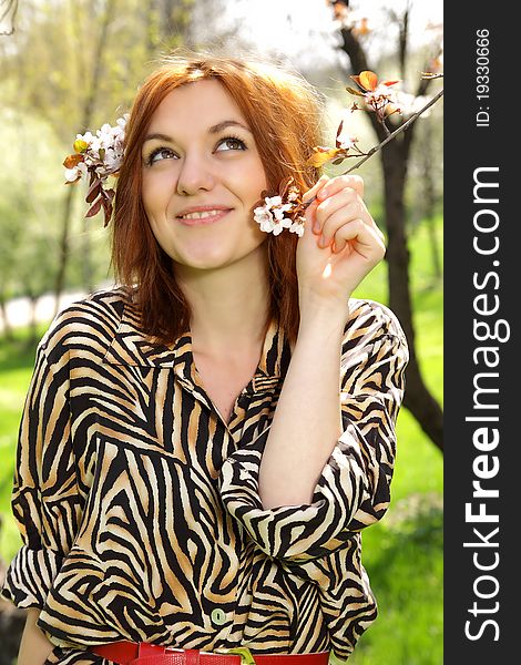 A beautiful red hair woman daydreaming in a spring beautiful spring day. Wears a anumal print top. A beautiful red hair woman daydreaming in a spring beautiful spring day. Wears a anumal print top.