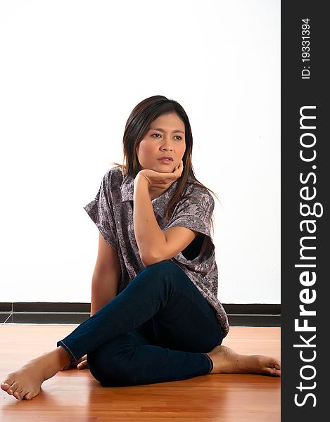 A beautiful young Asian woman siting on the floor