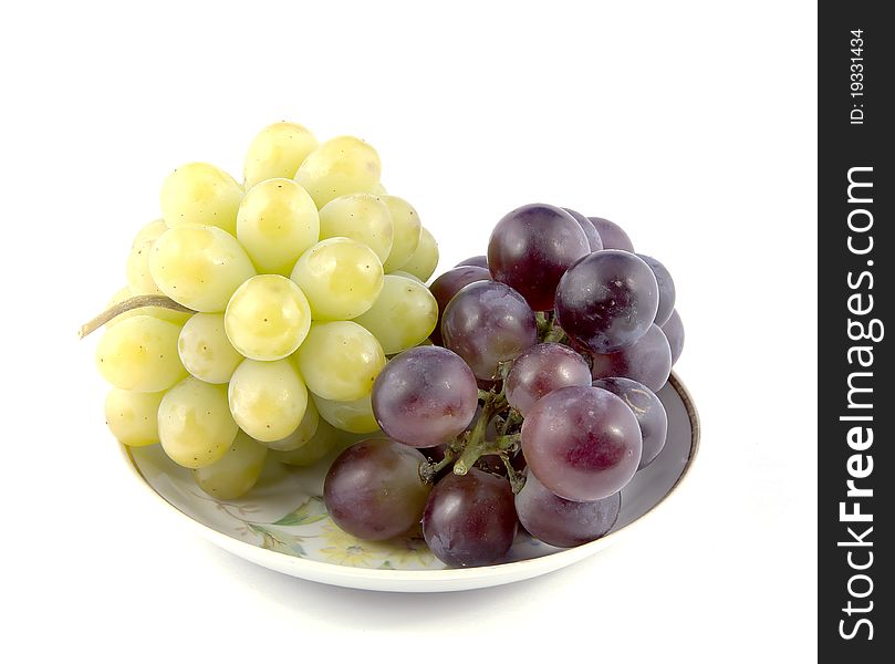 Red and green grapes in a small plate. Grapes on white background. Red and green grapes in a small plate. Grapes on white background