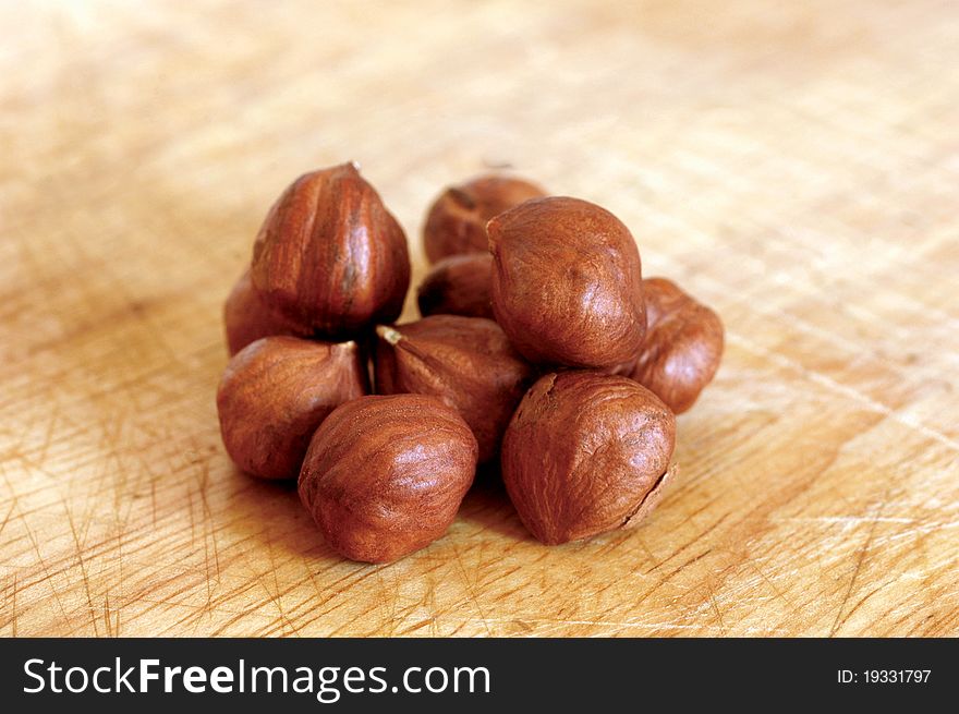 Heap of hazelnuts on wooden background