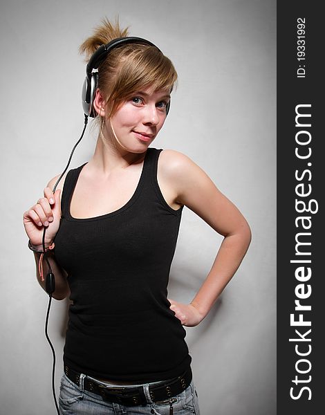 Late teen attractive chick posing with stereo headset on her head. Late teen attractive chick posing with stereo headset on her head