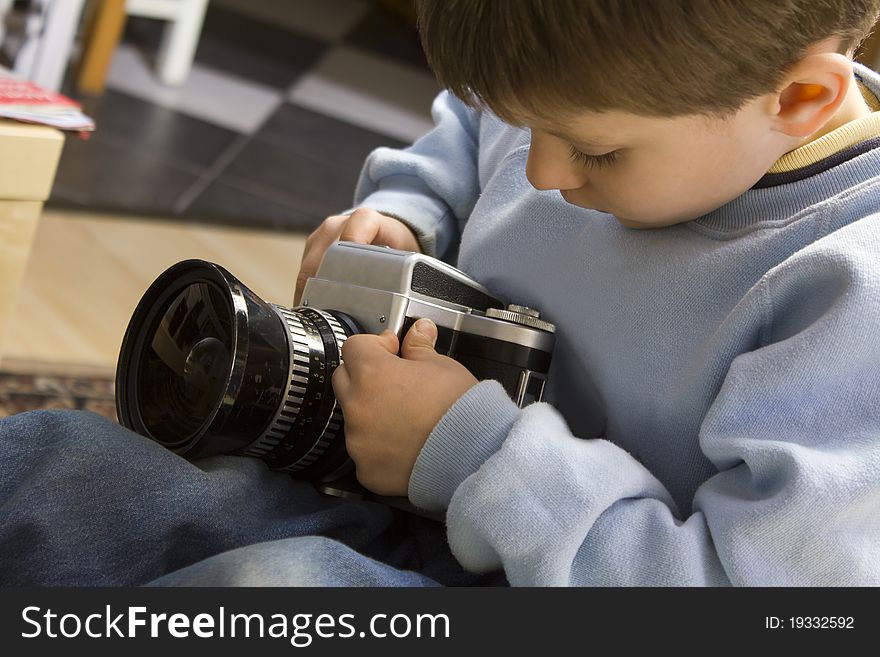 Young boy examining a vintage medium format camera. Young boy examining a vintage medium format camera